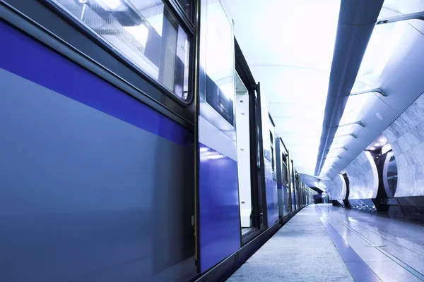 Blauwe snelle trein verblijven platform — Stockfoto