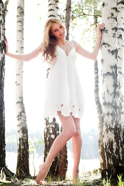 Mooi meisje in het wit in de buurt van berk — Stockfoto