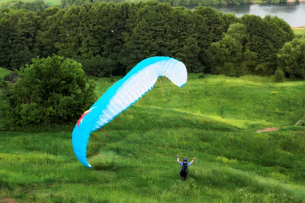 Çimenlerin üzerinde renkli aşırı paraglide — Stok fotoğraf