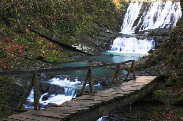 Cachoeira com a ponte de madeira — Fotografia de Stock