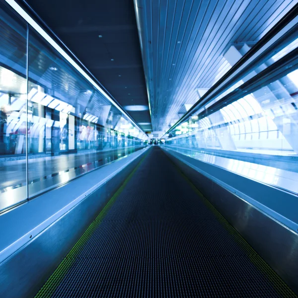 Blue moving escalator in the office hall Stock Image