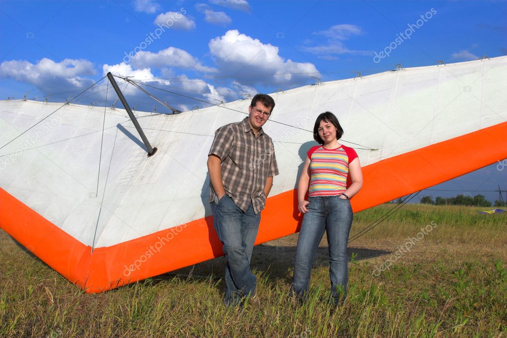 Smiling pair near paraglide wing