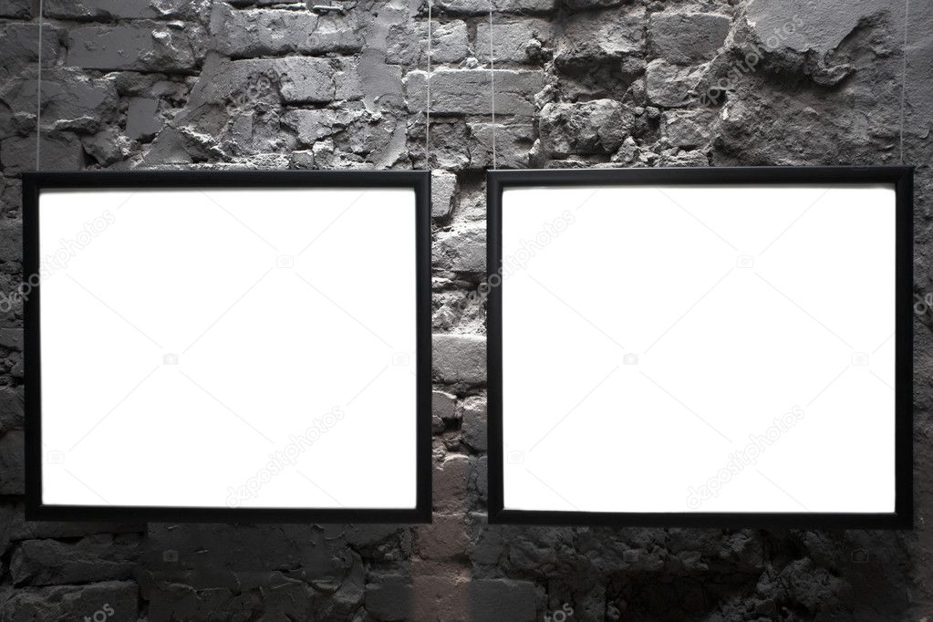 Two empty frames on brick wall