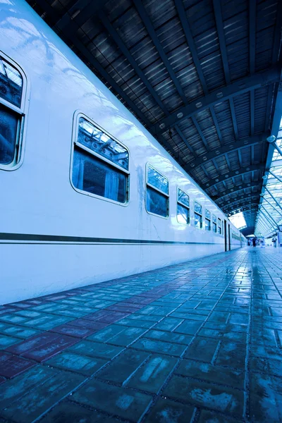 Zug bewegt sich auf nassem Bahnsteig — Stockfoto