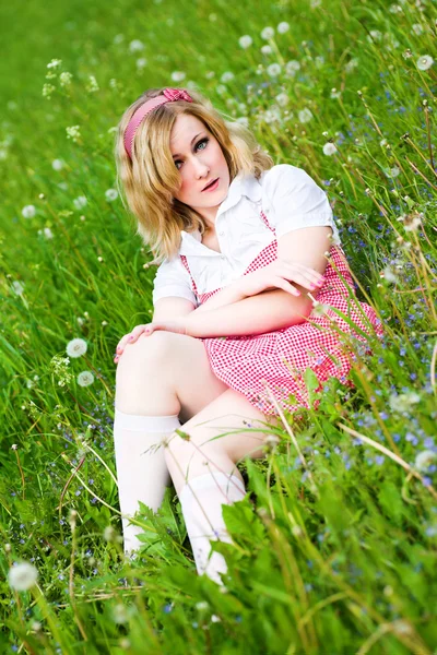 Loira atraente menina sentar na grama — Fotografia de Stock