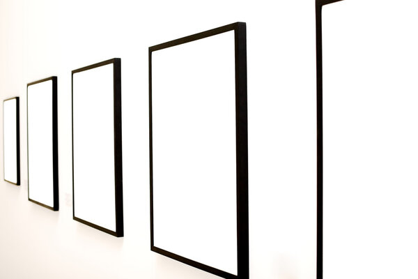 Five empty frames on white wall exhibition in Museum