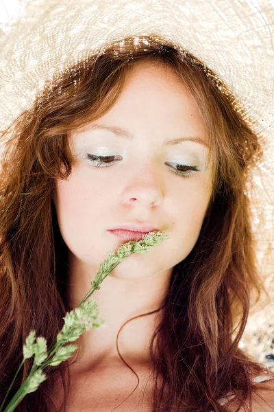 Usmívající se dívka v klobouku s trávou — Stock fotografie