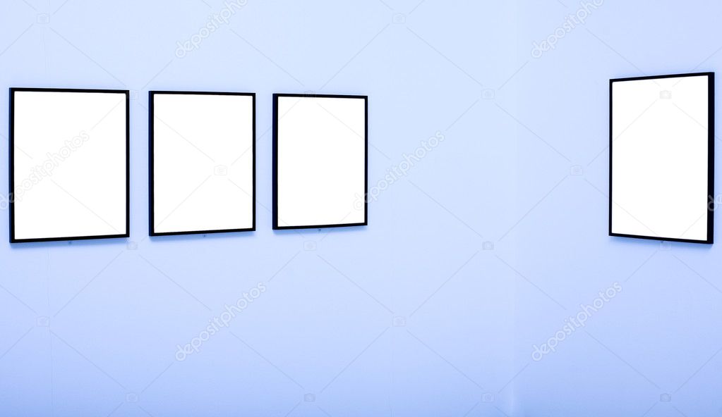 Four white empty frames on blue wall