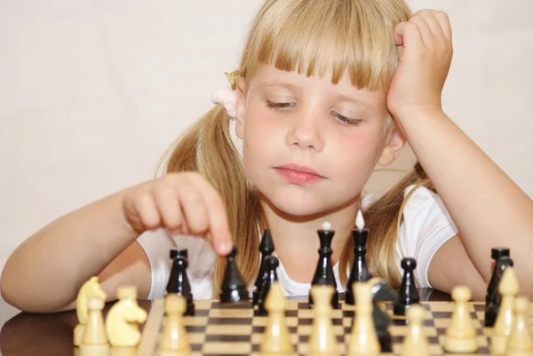 stock image The girl in a pink dress plays a chess