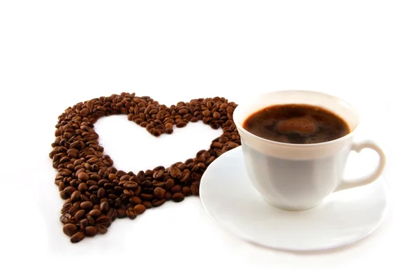 Tasse Kaffee mit einem Herz aus Kaffeebohnen — Stockfoto