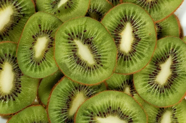 Green background slices kiwi — Stock Photo, Image