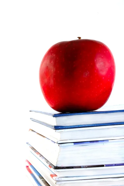 Учебники с яблоком на белом фоне — стоковое фото