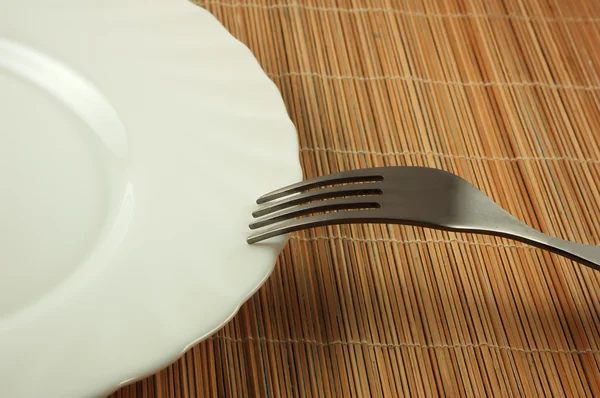 Пустая тарелка и вилка — стоковое фото