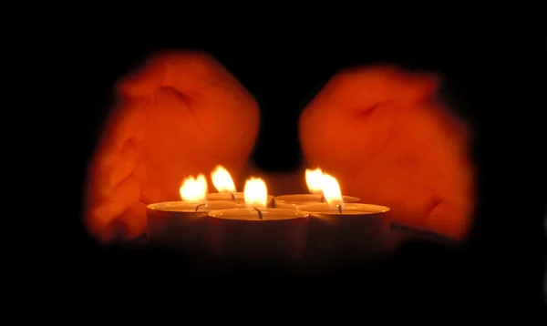 Rukama uchopil kolem svíčky — Stock fotografie