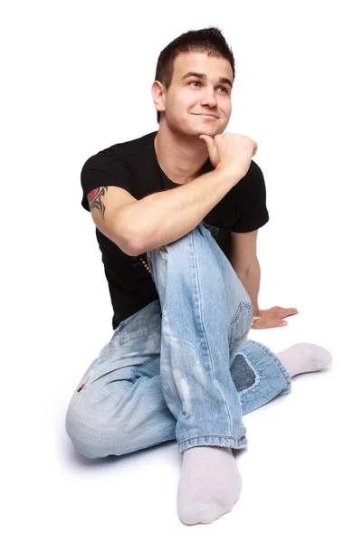 Mladý muž sedící na podlaze — Stock fotografie