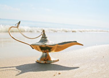 Genies lamp on seashore clipart