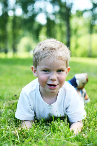 緑の芝生の上に横に小さな子供 — ストック写真