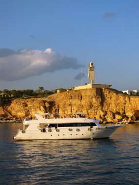 Tekne ve deniz feneri günbatımı