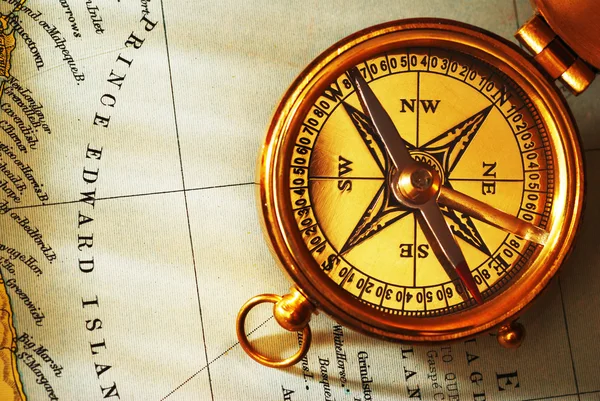 Античный латунный компас над старым канадским — стоковое фото