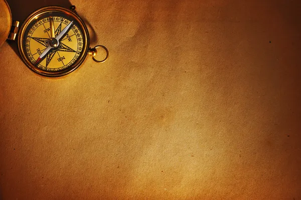 Античний латунний компас над старим фоном — стокове фото
