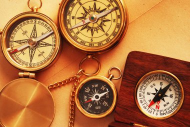 Four antique compasses over old backgrou clipart