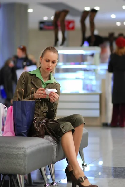 Flicka undersöker räkningen i shopping m — Stockfoto