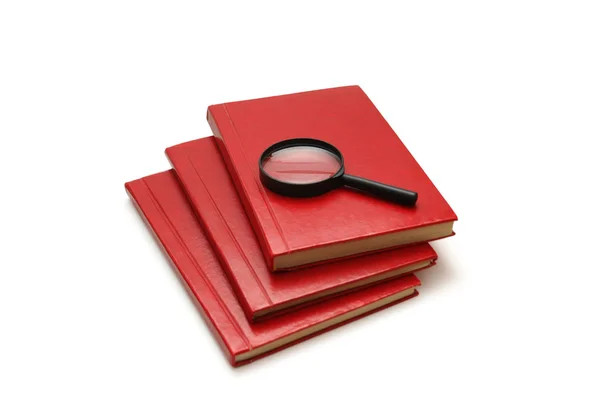 Magnifying glass over the stack of books — Stock Photo, Image