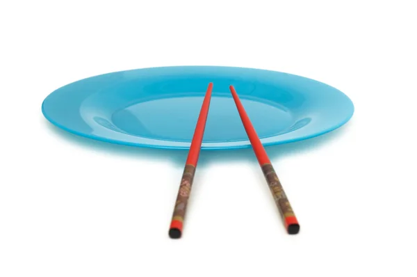 Red chopsticks on plate — Stock Photo, Image