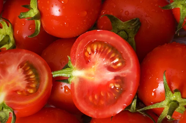 Meio corte e tomates inteiros na martke — Fotografia de Stock