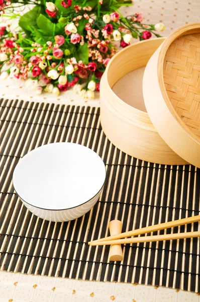 Palillos y tazón en la estera de bambú —  Fotos de Stock