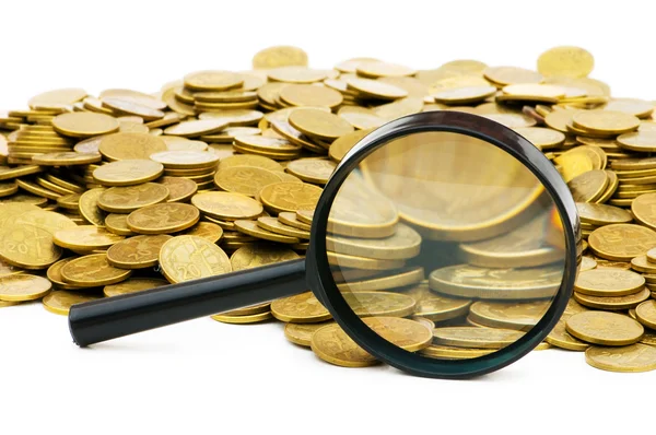 Magnifying glass and lots of gold coins — Stock Photo, Image