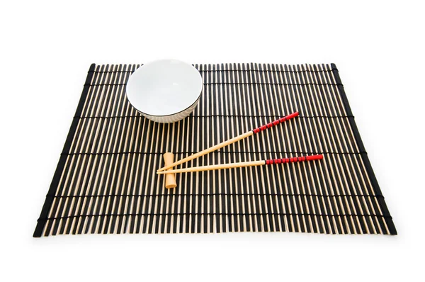 Yemek çubukları ve bambu hasır üzerinde plaka — Stockfoto