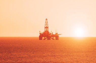 Oil platform at the sunrise clipart