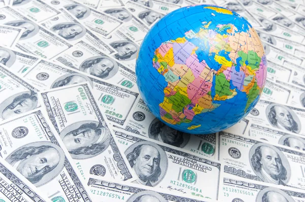 stock image Globe over many dollar bank notes