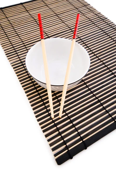 Palillos y plato en la estera de bambú —  Fotos de Stock