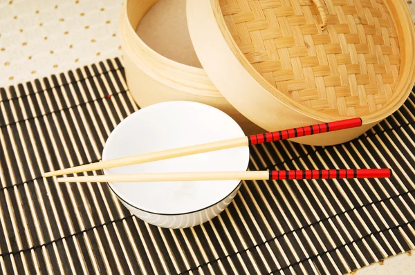 Essstäbchen und Schale auf der Bambusmatte — Stockfoto