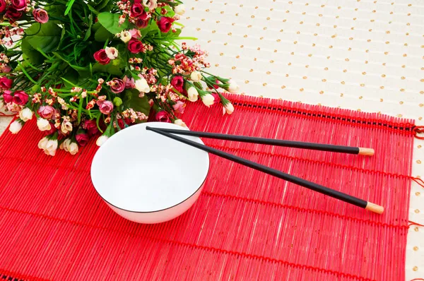 Chopsticks e tigela no tapete de bambu — Fotografia de Stock