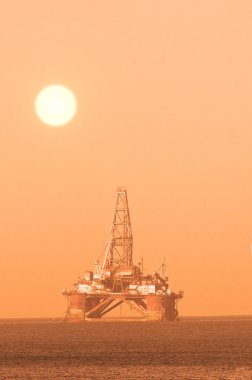 Oil platform during sunset clipart