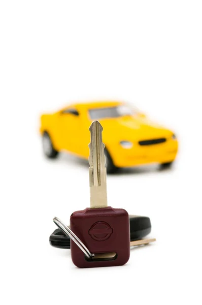 Τα κλειδιά του αυτοκινήτου και το αυτοκίνητο στο υπόβαθρο — Φωτογραφία Αρχείου