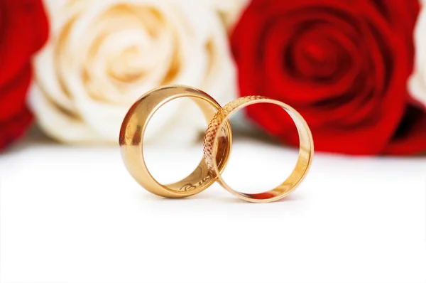 Золотые кольца и розы изолированы — стоковое фото
