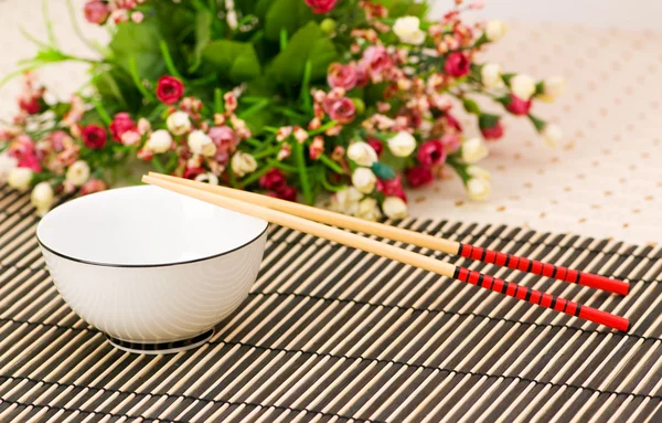 Chopsticks and bowl on the bamboo mat — Stock Photo, Image