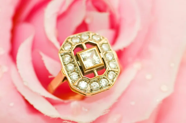 Χρυσό δαχτυλίδι ενάντια ροζ τριαντάφυλλο — Φωτογραφία Αρχείου