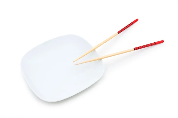 Chopsticks and plate on white — Stock Photo, Image