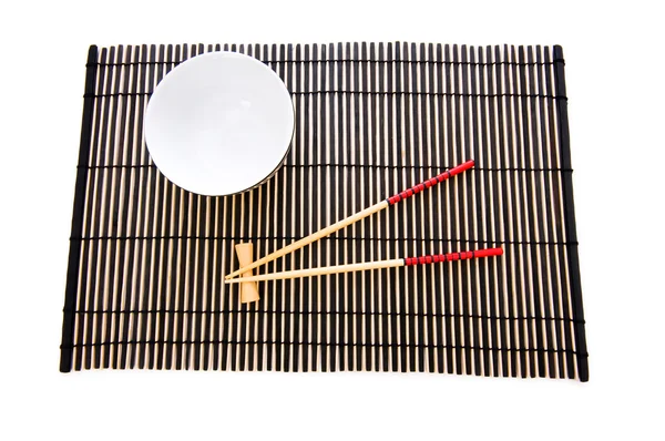 Палички і тарілка на бамбуковому килимку — стокове фото