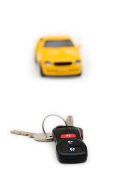 Autoschlüssel und Auto im Hintergrund isoliert — Stockfoto