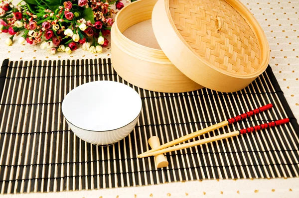 Palillos y tazón en la estera de bambú — Foto de Stock