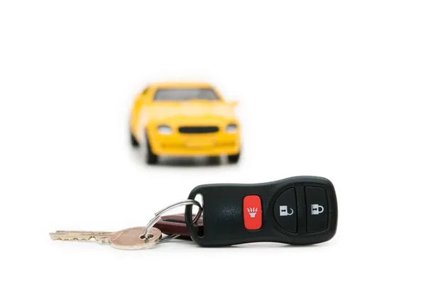 Auton avaimet ja auton taustalla — kuvapankkivalokuva