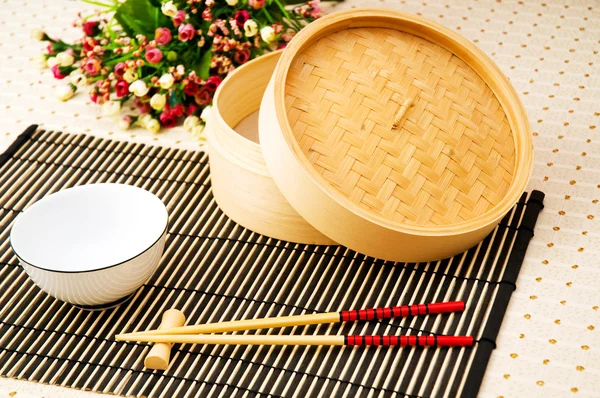 Baguettes et bol sur le tapis de bambou — Photo