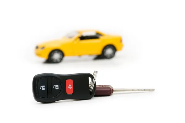 Auton avaimet ja auto taustalla eristetty — kuvapankkivalokuva