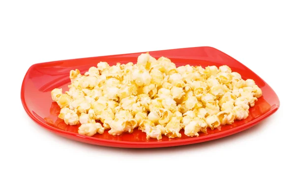 Popcorn na czerwony talerz na białym tle — Zdjęcie stockowe